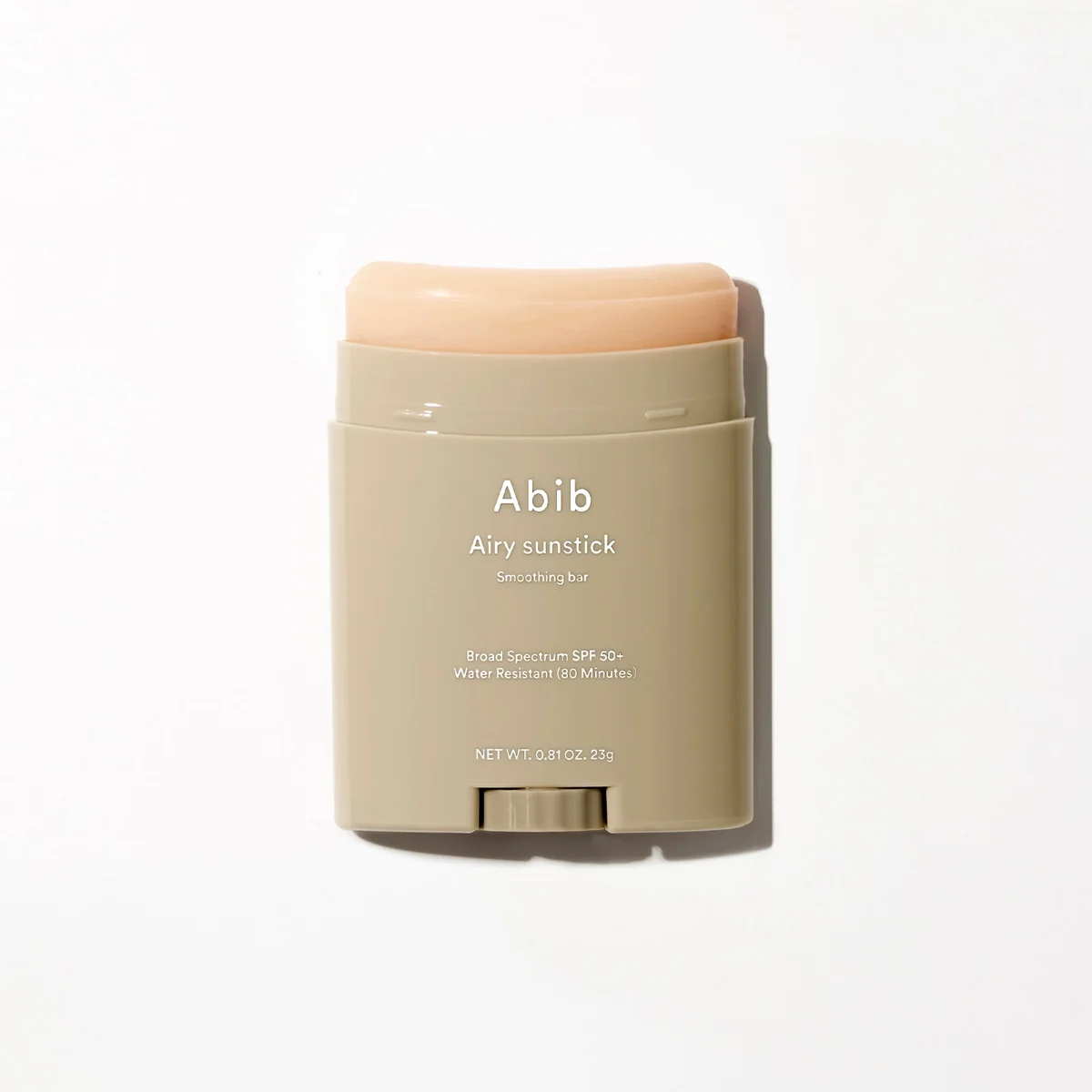 Abib Airy Sunstick Smoothing Bar SPF50+ — beige stick case with the peach-coloured balm wound up