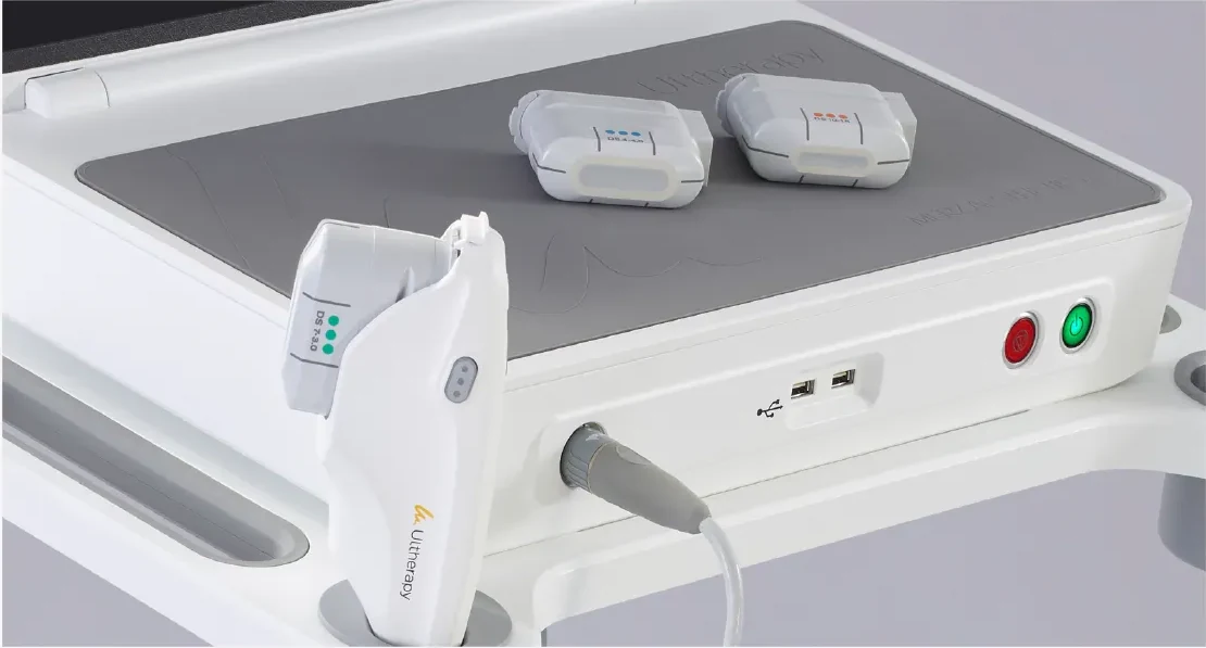 Ultherapy handpiece with a transducer attached, and two more transducers for other depths resting on the machine